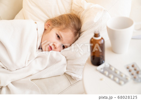 kid girl lying on sofa and ill. cure for cold. 68028125