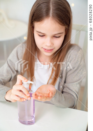 teen girl uses disinfectant to clean their hands. 68028290