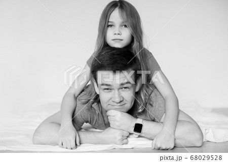 daddy and daughters lying on floor. black-white. 68029528