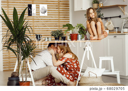 mom, dad and daughters gaming in the kitchen  68029705