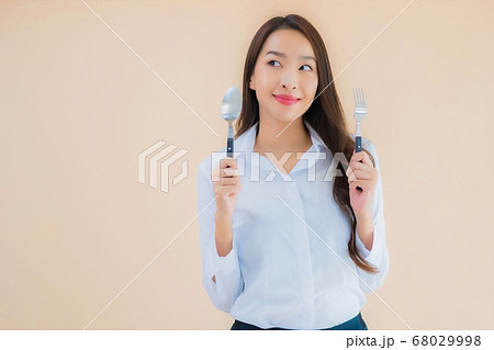 Portrait beautiful young asian business woman with spoon and fork 68029998