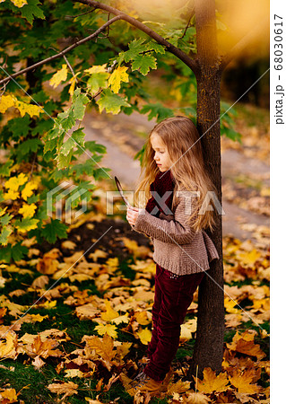 dreamy girl under tree in autumn Park with feather 68030617