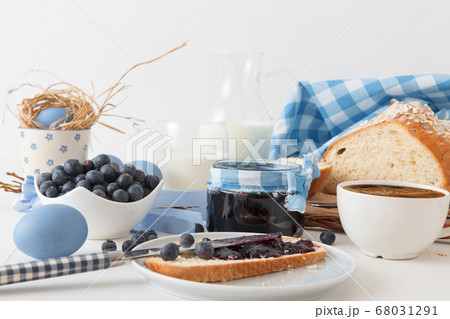 Breakfast with Easter symbols, traditional Czech pastry Mazanec, Pomlazka and eggs in blue style. 68031291