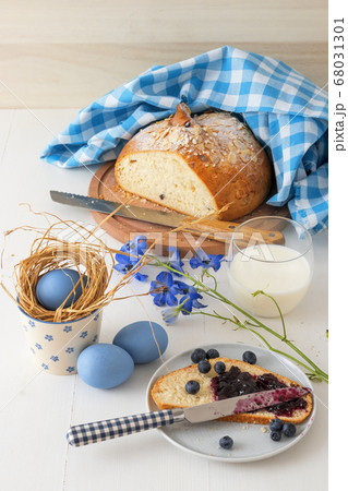 Breakfast with Easter symbols, traditional Czech pastry Mazanec, Pomlazka and eggs in blue style. 68031301