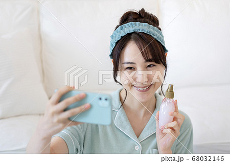 化粧水のボトルを持って自撮りする若い女性 インフルエンサー イメージ 化粧水のボトルを持って自撮りする若い女性 インフルエンサー イメージ 68032146