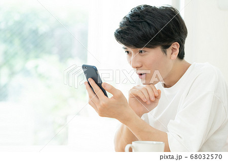 スマホでコミュニケーションする男性 68032570