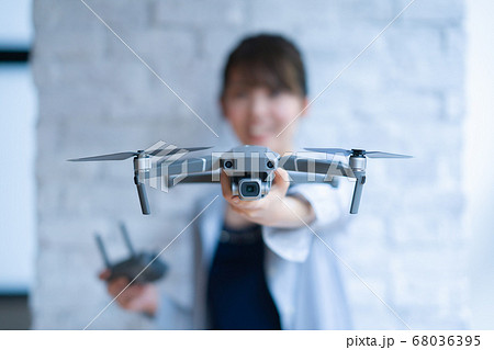 ドローン ビジネス カジュアル オフィス  女性 1人 商談 空撮 窓際 手元 操作 趣味 飛行機 68036395