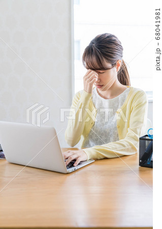 長期化するテレワークで疲弊する若い女性 【眉間に手を当てる】 68041981