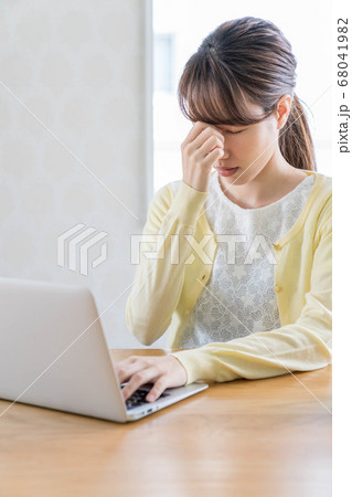 長期化するテレワークで疲弊する若い女性 【眉間に手を当てる】 68041982