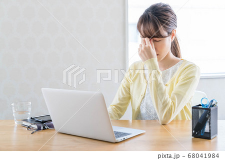 長期化するテレワークで疲弊する若い女性 【眉間に手を当てる】 68041984