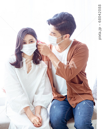 Young asian couple wearing surgical mask and using Ear thermometer Young asian couple wearing surgical mask and using Ear thermometer 68042088