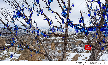 Blue Evil eye charms hang on the tree in Cappadocia, Turkey Blue Evil eye charms hang on the tree in Cappadocia, Turkey 68042704