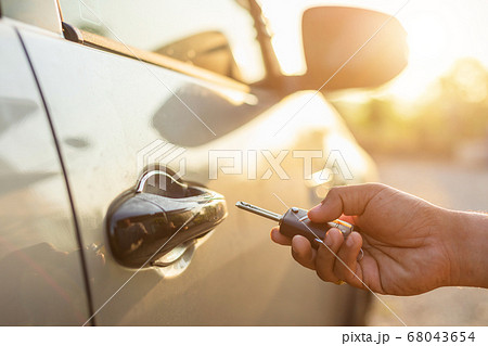 Hand holding remote car keys and press the button Hand holding remote car keys and press the button 68043654