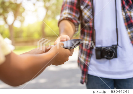 Asian tourist picking up his black wallet from 68044245