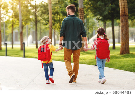 Children walking to school with father. 68044483