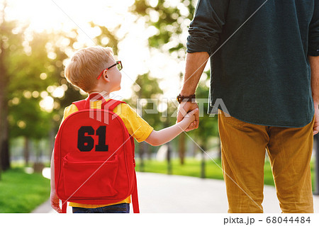 Crop man and schoolboy in park. Crop man and schoolboy in park. 68044484