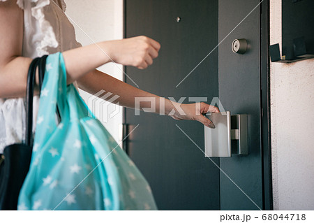 ドアノブに触れる女性 68044718