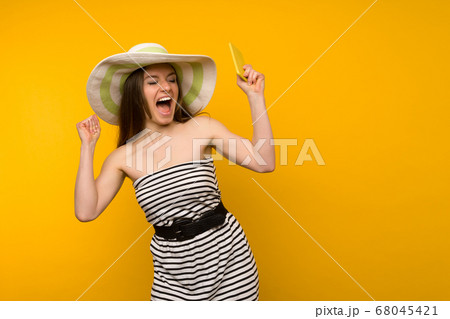 Girl wears straw hat and short white strips dress Girl wears straw hat and short white strips dress 68045421