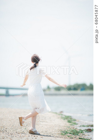 海辺を歩く若い女性 68045877