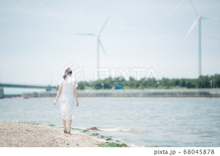 海辺を歩く若い女性 68045878