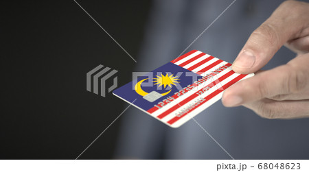 Man gives plastic bank card with printed flag of Malaysia. Fictional numbers Man gives plastic bank card with printed flag of Malaysia. Fictional numbers 68048623