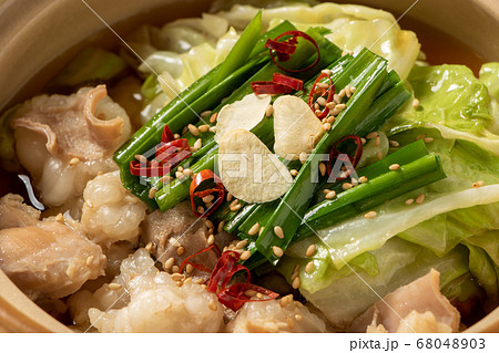 一人前サイズの小さな土鍋に入れられたもつ鍋のアップ の写真素材