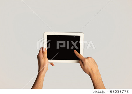 Unrecognizable man touching screen of modern tablet computer on light background, mockup for design Unrecognizable man touching screen of modern tablet computer on light background, mockup for design 68053778