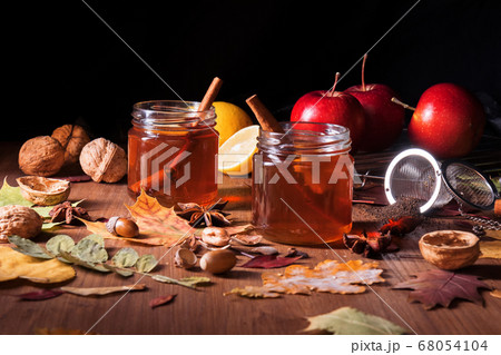 Dark wooden table with 2 glasses of tea with fall, autumn decoration Dark wooden table with 2 glasses of tea with fall, autumn decoration 68054104