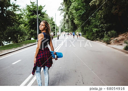 girl posing with skate board 68054916