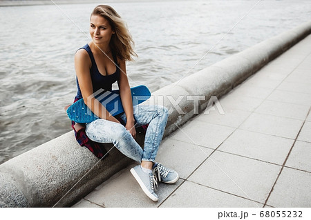 beautiful blonde woman posing with a skateboard beautiful blonde woman posing with a skateboard 68055232