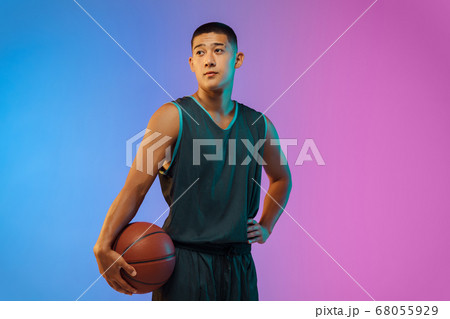 Young basketball player in motion on gradient studio background in neon light 68055929