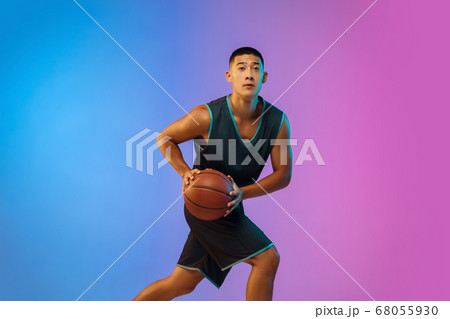Young basketball player in motion on gradient studio background in neon light 68055930