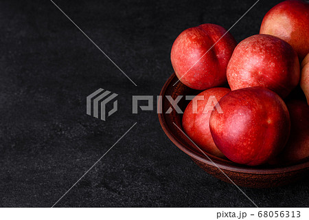 Delicious sweet peaches or nectarines in a brown Delicious sweet peaches or nectarines in a brown 68056313
