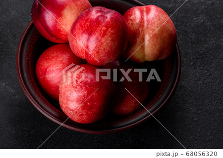 Delicious sweet peaches or nectarines in a brown 68056320