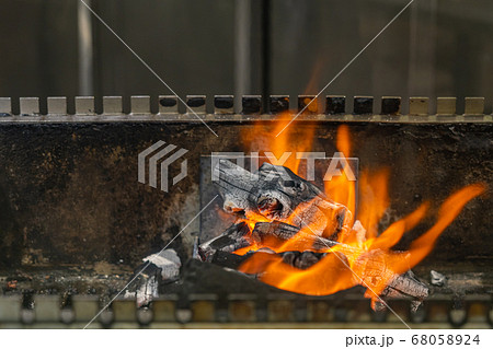 Hot flaming fire on charcoal grilling machine in restaurant 68058924