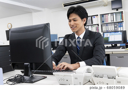パソコンでディスクワークをする若い男性ビジネスマン 68059089