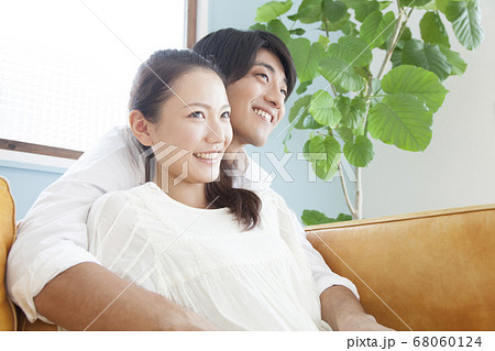 ソファで寛ぐ新婚夫婦 68060124