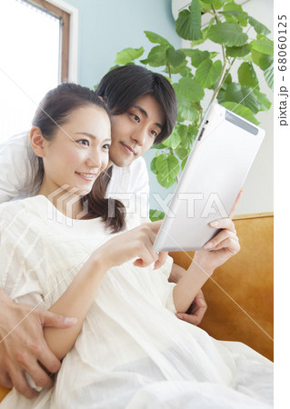 タブレットPCを見る新婚夫婦 タブレットPCを見る新婚夫婦 68060125