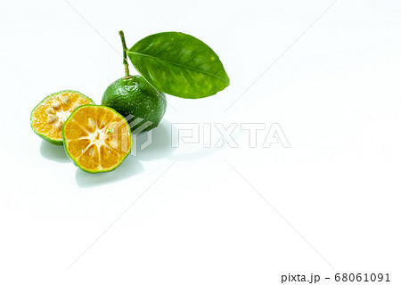 夏が旬の沖縄観光に人気の積んである青いシークワサーの輪切りの実と葉っぱ付きの実 68061091