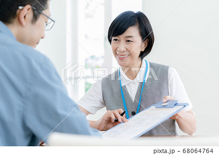 介護施設への入居説明をする職員の女性 介護施設への入居説明をする職員の女性 68064764