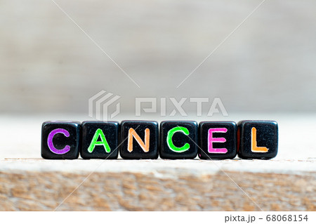 Black bead with color letter in word cancel on wood background Black bead with color letter in word cancel on wood background 68068154