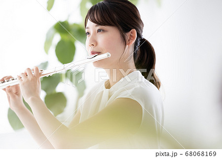 フルート吹く若い女性の写真素材 フルート吹く若い女性の写真素材