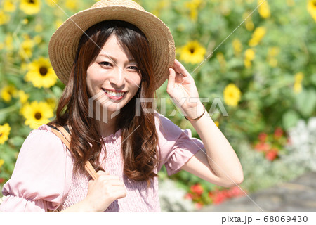 ひまわり畑と笑顔の若い女性 68069430