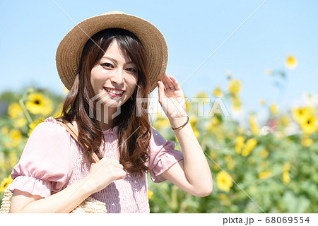 ひまわり畑と笑顔の若い女性 68069554