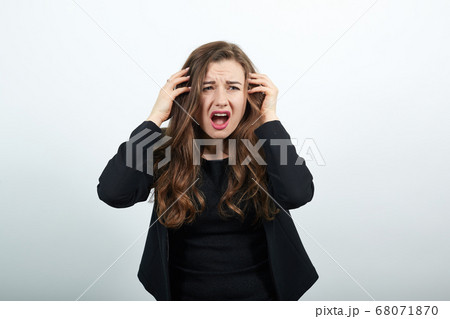 Angry, Irritated Female Holds Hands To Her Head And Screams. People's Hysteria Angry, Irritated Female Holds Hands To Her Head And Screams. People's Hysteria 68071870