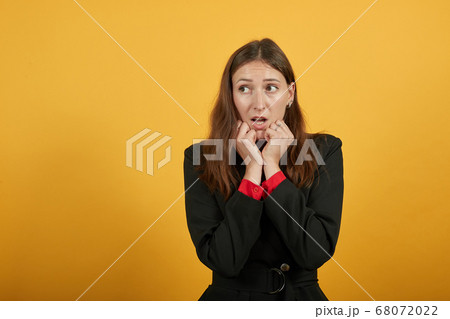 Scared Woman Clenched Hands Into Fists, Holds Them To Face. Fear, Uncertainty 68072022