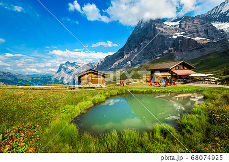 Small pond with wooden huts in the mountains, Grindelwald, Switzerland  68074925