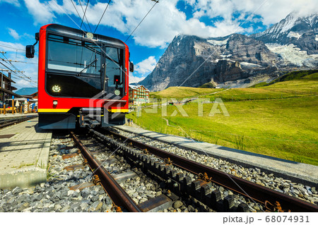 Electric red passenger train parked in the mountain station, Switzerland 68074931
