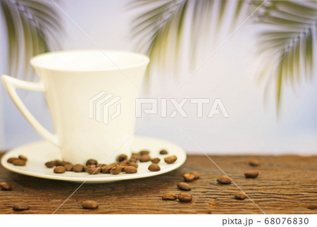 a cup of coffee on wood on blurred palm leaf a cup of coffee on wood on blurred palm leaf 68076830