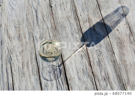 Glass of white wine on vintage wooden table Glass of white wine on vintage wooden table 68077140